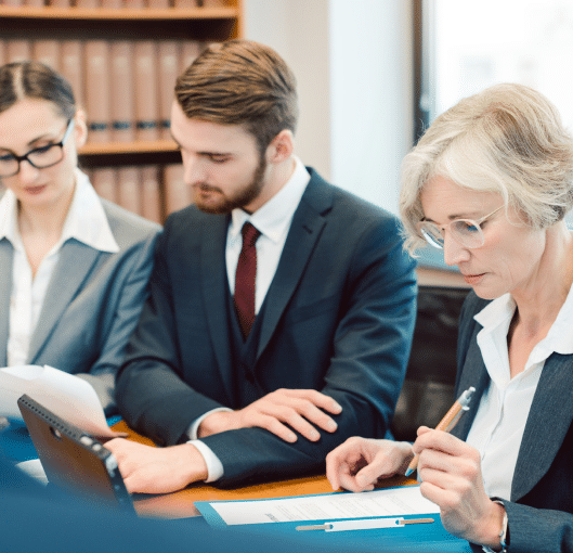 2 women and 1 man working together in suits