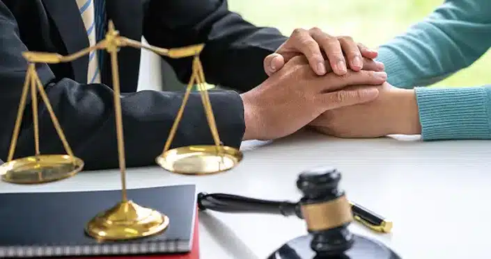 lawyer holding client hand on lawyer desk