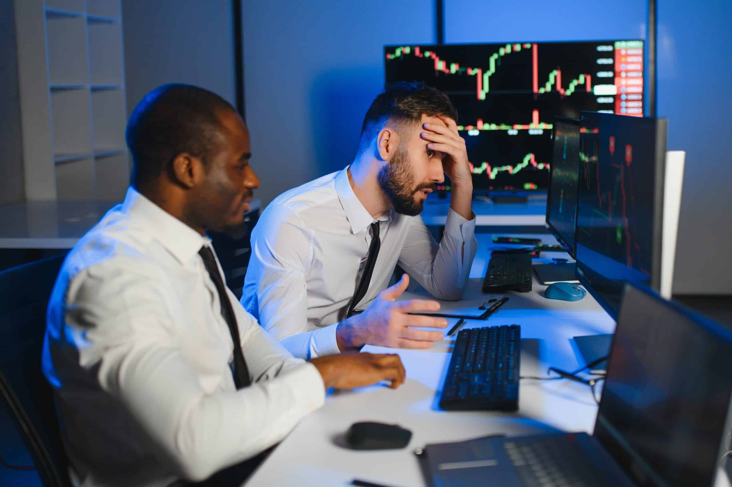 Conception of teamwork. Team of stockbrokers works in modern office with many display screens.