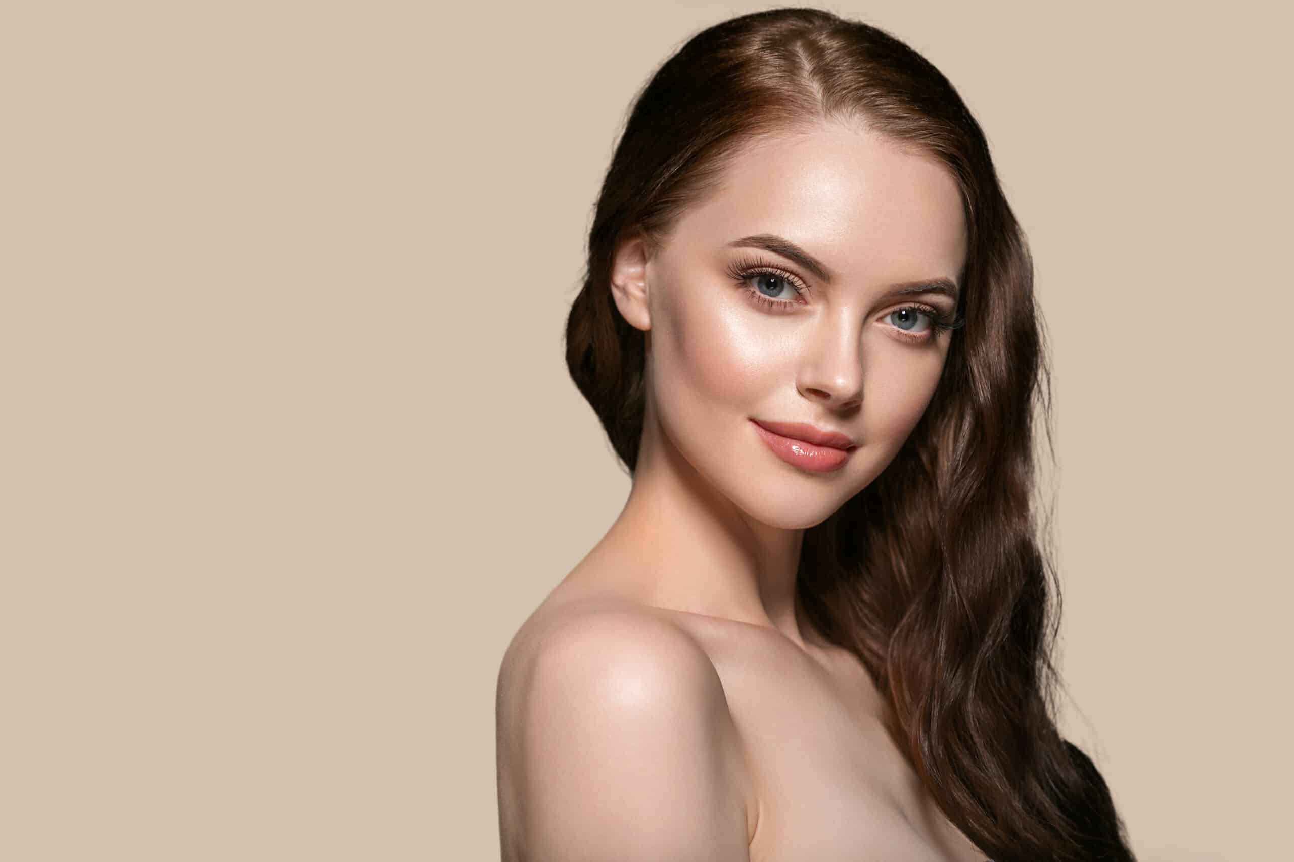 Beautiful hair skin woman beauty female portrait natural make up long hair. Color background brown