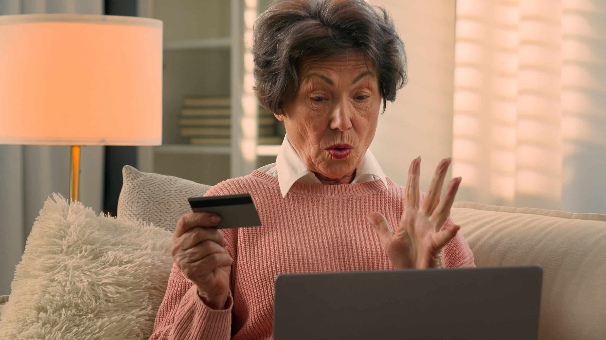 Happy senior satisfied aged Caucasian woman joyful excited retired old mature female at home sofa shopping online celebrate successful payment with laptop pay internet banking kiss credit bank card. High quality 4k footage