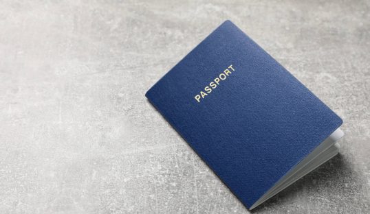 Blank blue passport on grey table , space for text