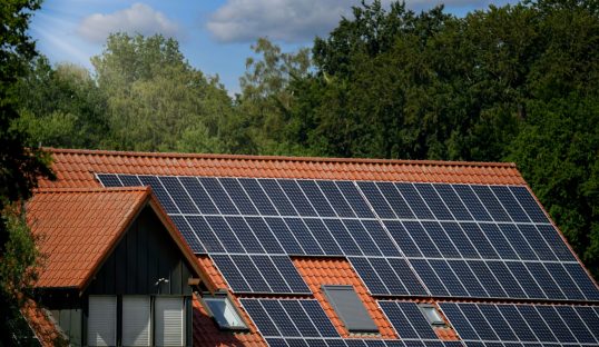 A closeup shot of a modern light brown roof covered with dark blue solar panels
