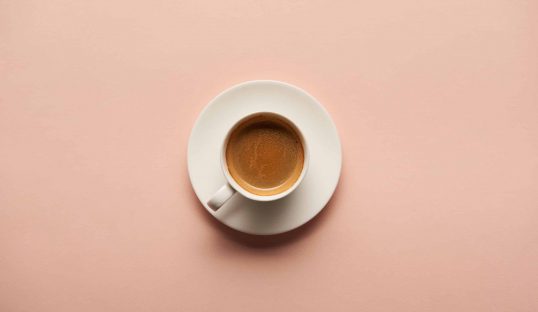 top view of tasty espresso in white cup on pink background